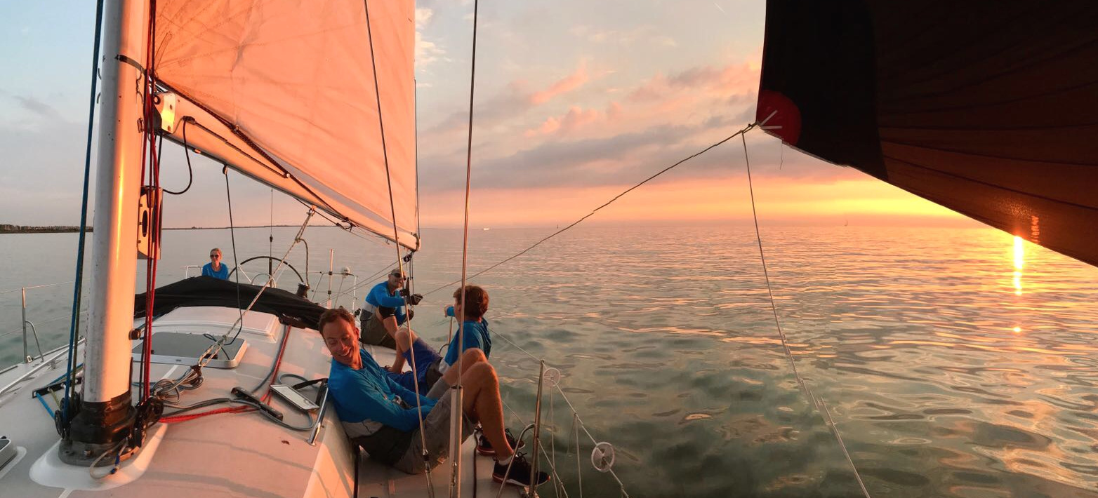 Uit je comfortzone met zeilboot met ondergaande zon